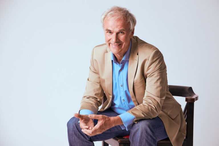 Harald Dill im Anzug sitzend